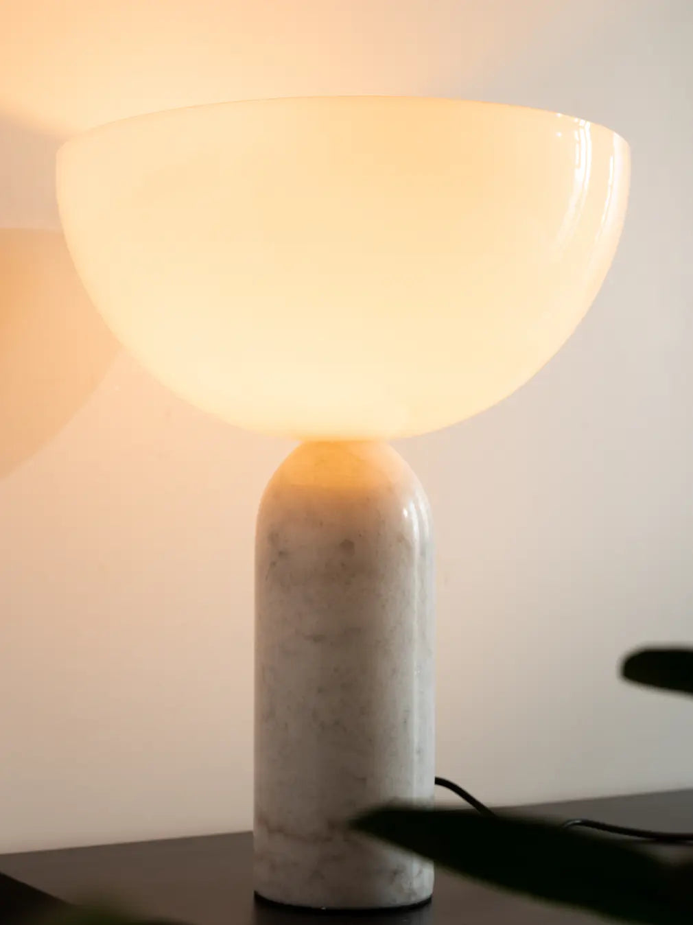 Close-up of premium lamp with solid marble base and curved white glass shade