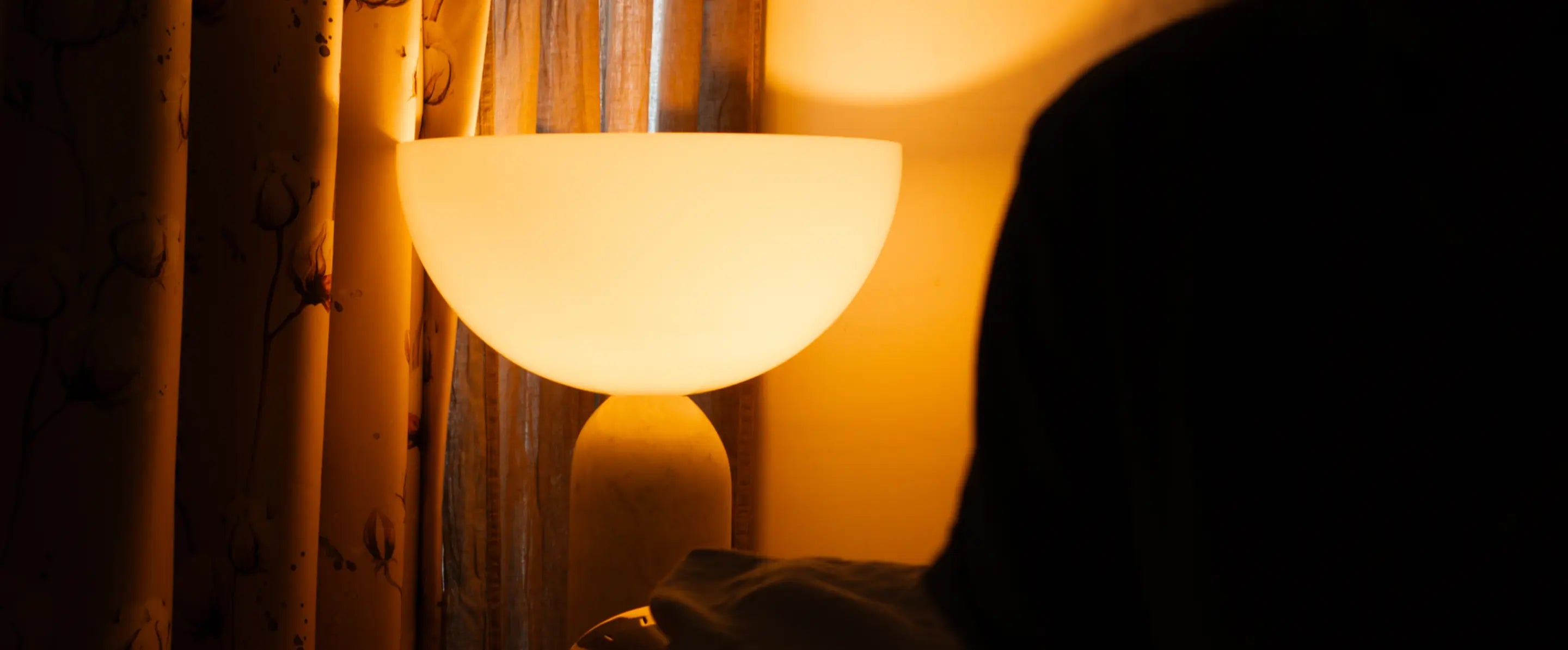 Arc Marble Table Lamp beside bed casting a diffused glow for cozy nighttime lighting