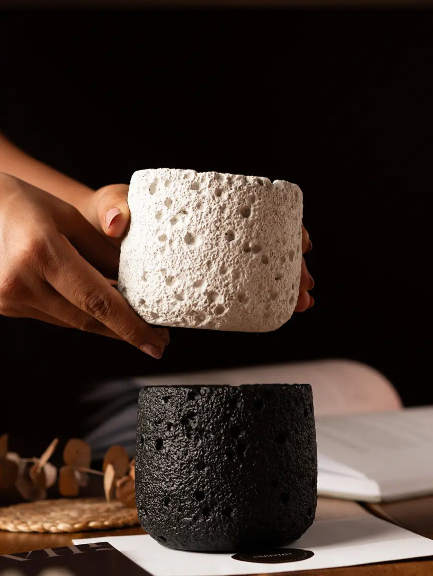 White and black Capri fragrance candles with volcanic texture design