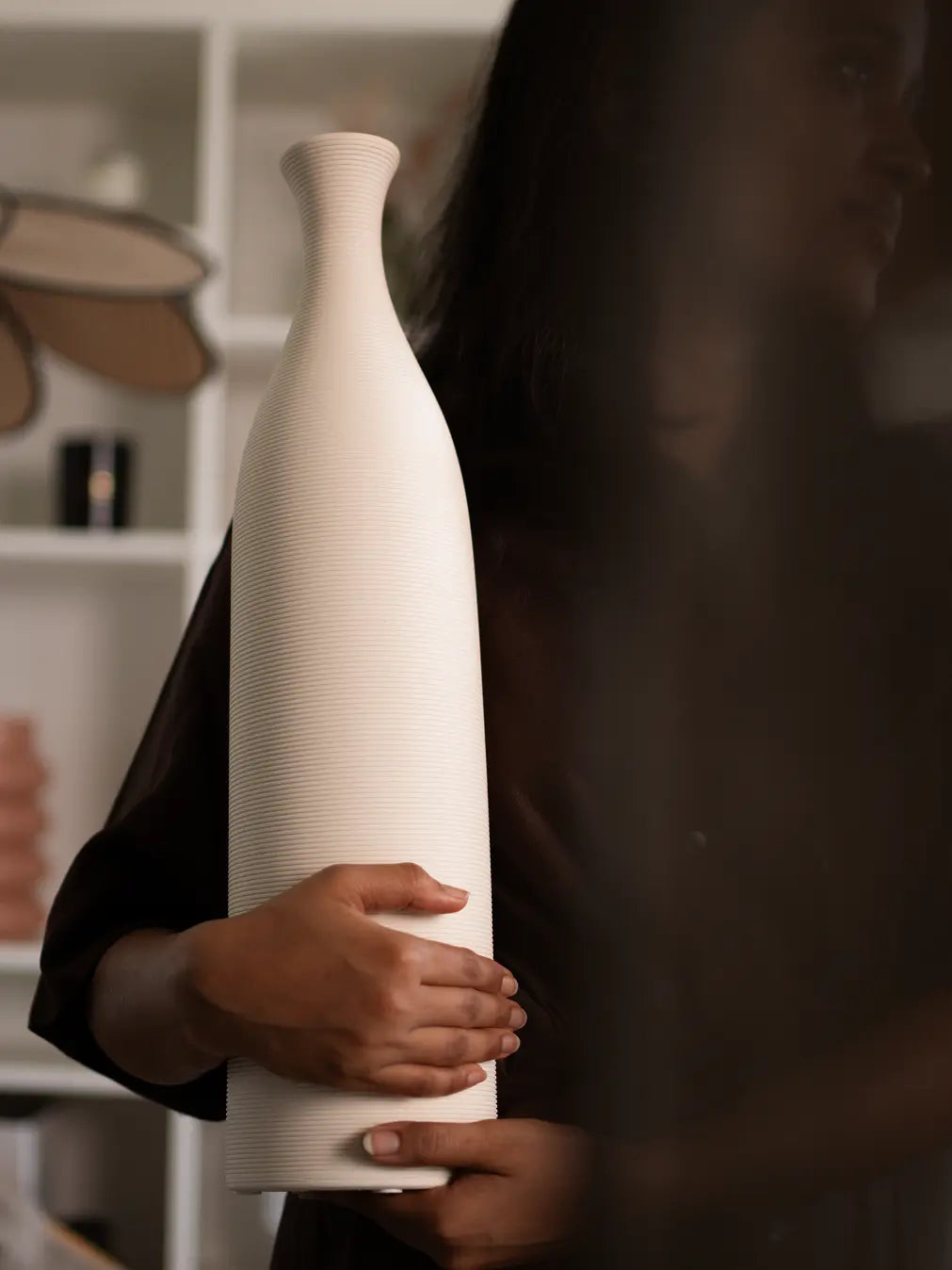 Tall Contour Ceramic Vase in white, featuring a ribbed texture and sculptural form, held in hands for scale.