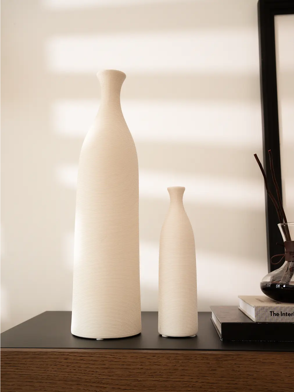 Set of two Contour Ceramic Vases in different sizes, displayed on a console table with soft natural lighting.