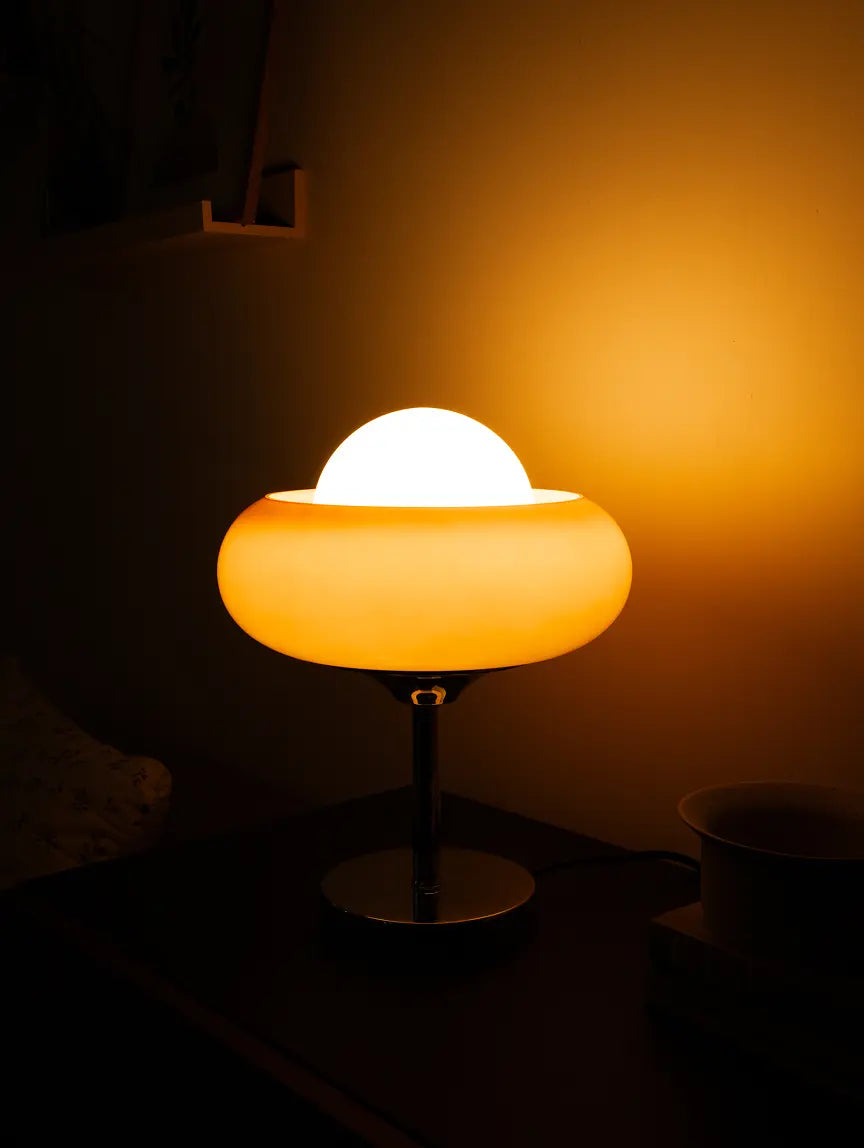 Dawn Glass Table Lamp with a glowing light bulb in a dark setting