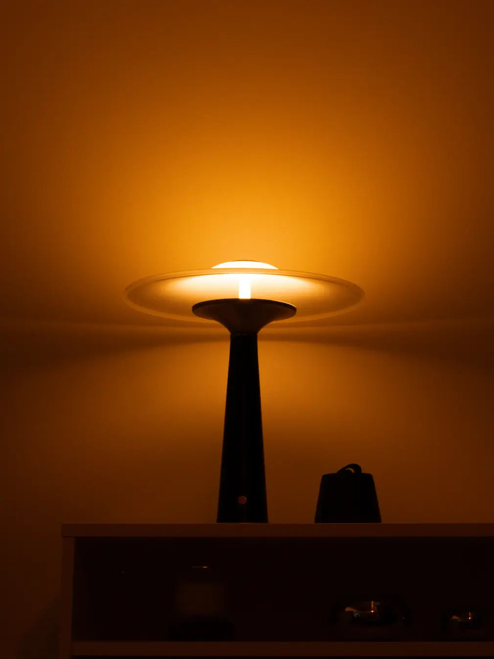 Warm LED glow from Disc Glass Table Lamp with frosted glass shade and black metal base