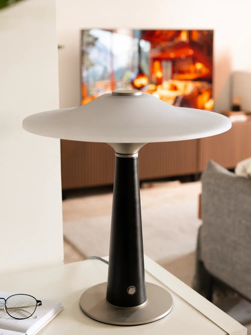Disc Glass Table Lamp placed in bright living room, showing frosted shade and sleek modern design