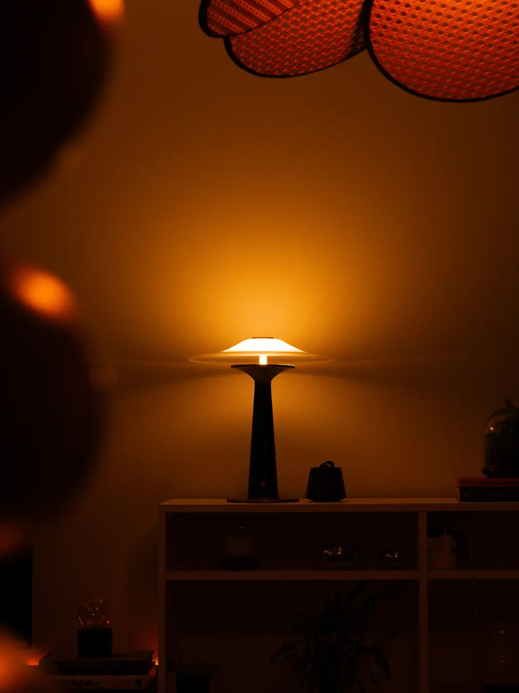 Disc Glass Table Lamp casting soft halo light in cozy setting with minimal console shelf styling
