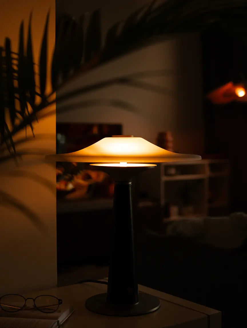 Disc Glass Table Lamp glowing in a modern living room with warm ambient lighting