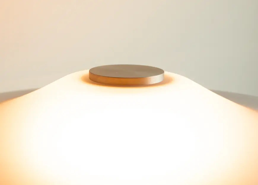 Close-up of frosted glass shade top with brushed metal detail on premium table lamp