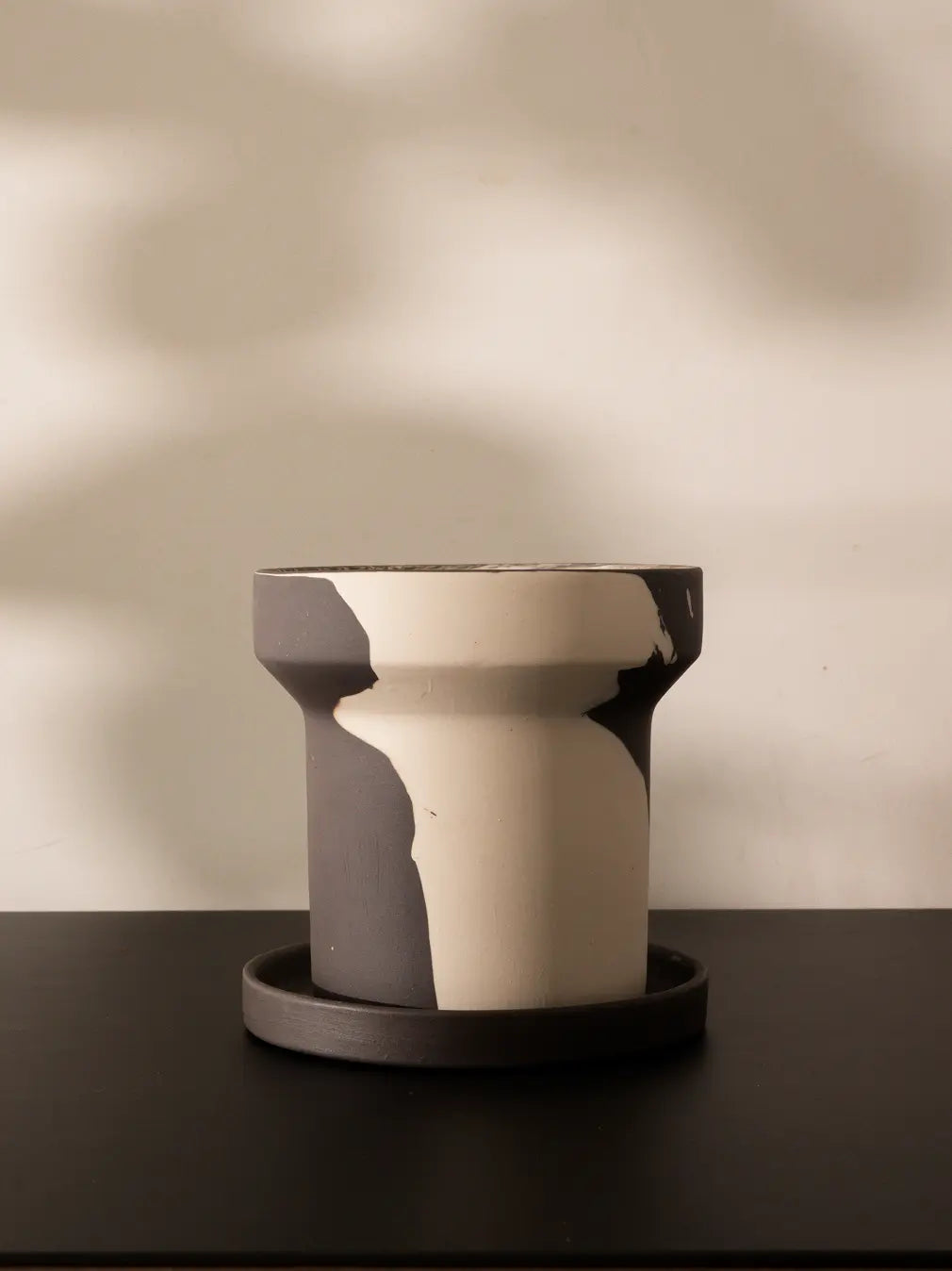 Close-up of premium ceramic pot showing dual-tone ceramic design with saucer.