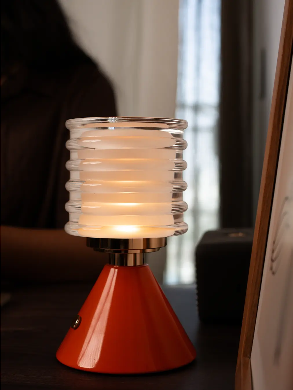 Dusk Table Lamp with orange aluminum base, soft LED illumination, and modern minimalist design