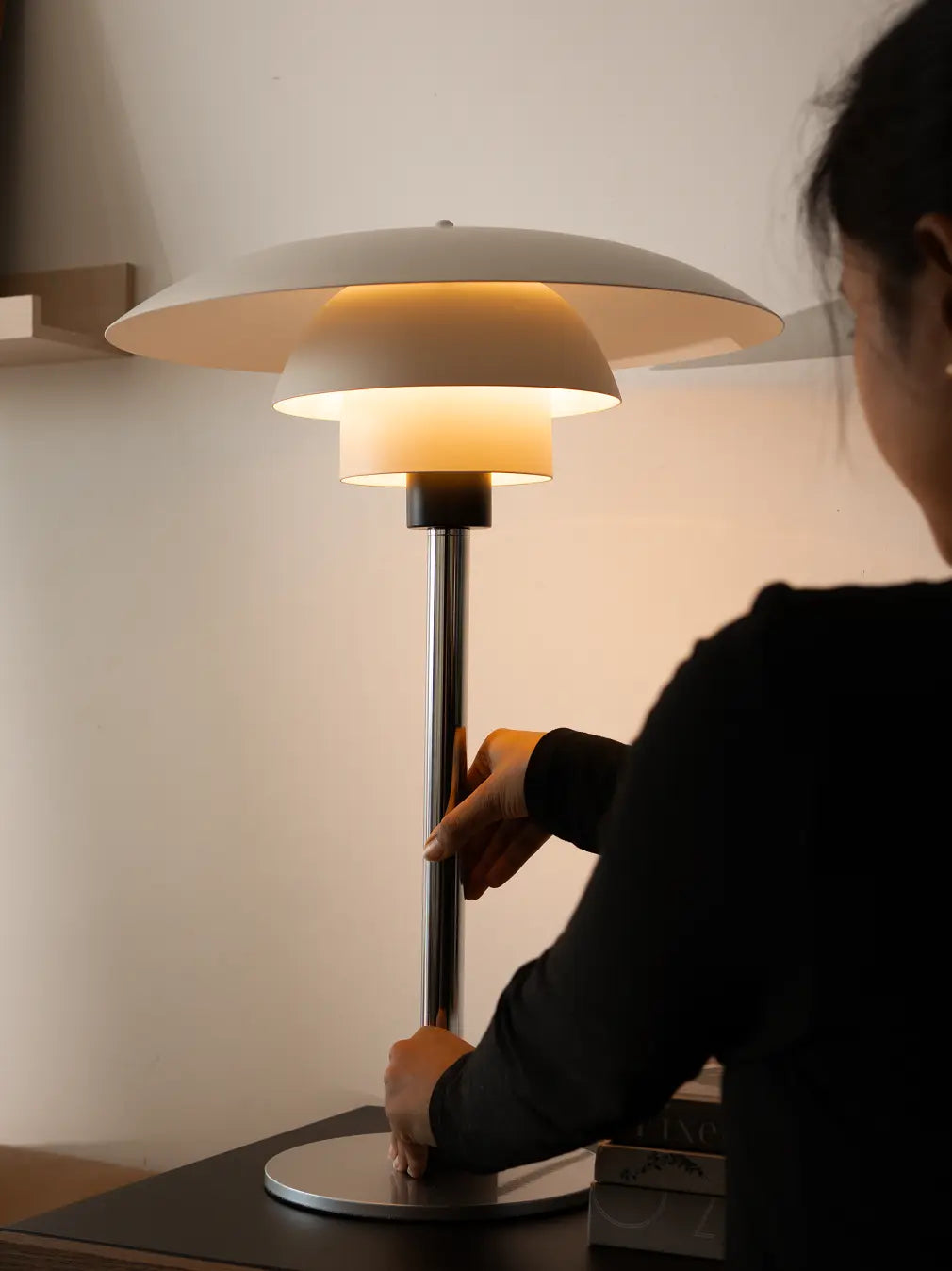 Modern Echo Metal Table Lamp being adjusted, showing silver stand and sculptural white shade