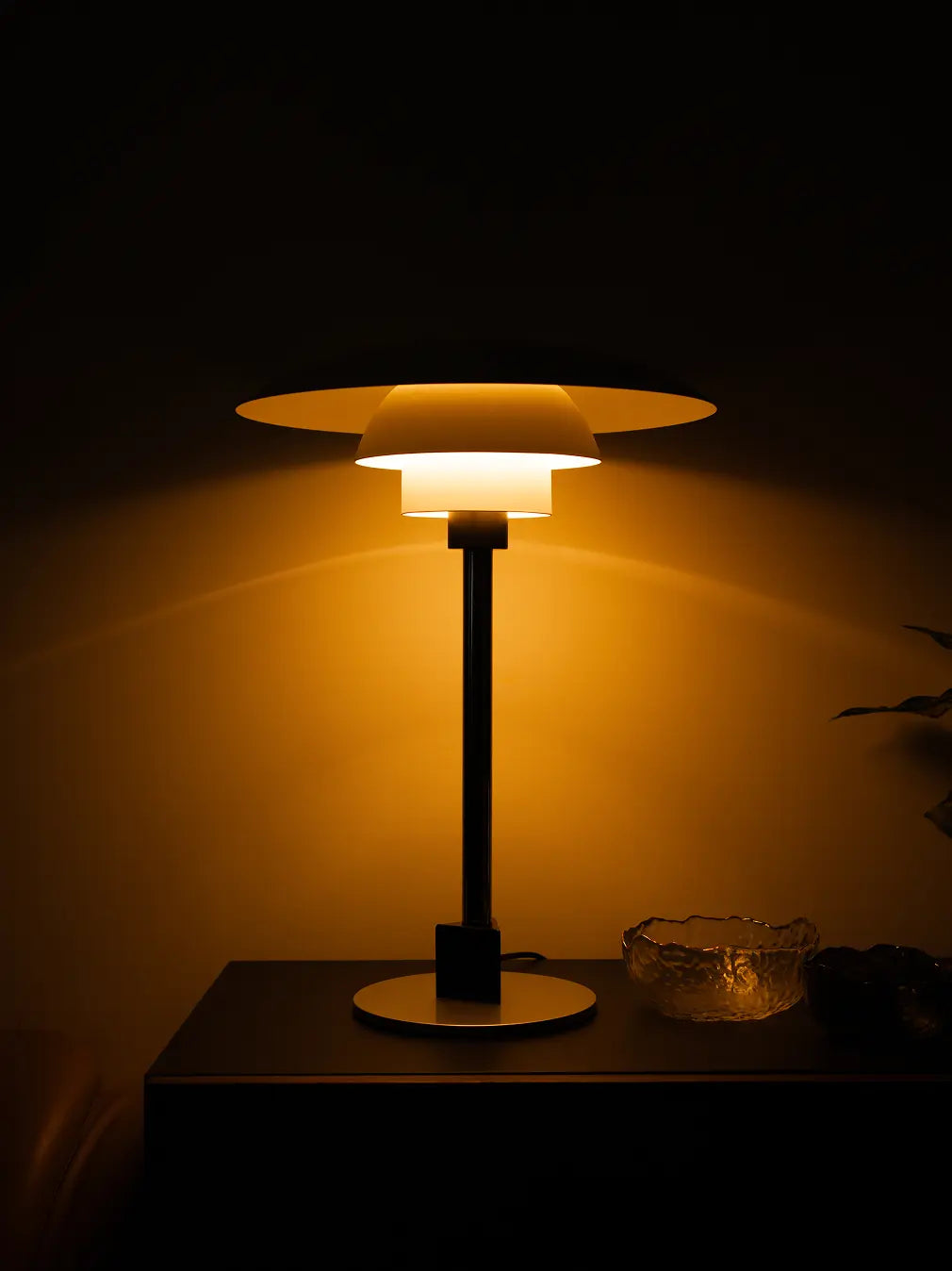 Echo Metal Table Lamp glowing warmly in dark room with soft 360-degree ambient lighting