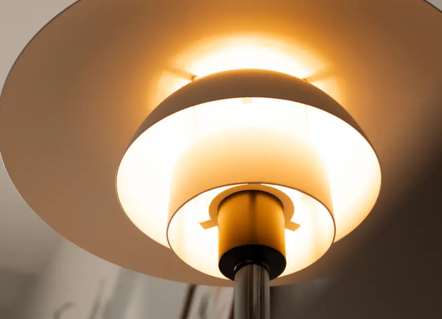 Underside view of Echo Lamp’s layered white shade glowing with warm diffused light