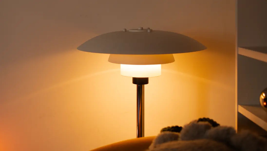 Echo Metal Table Lamp beside a couch, casting soft ambient light on a warm-toned wall