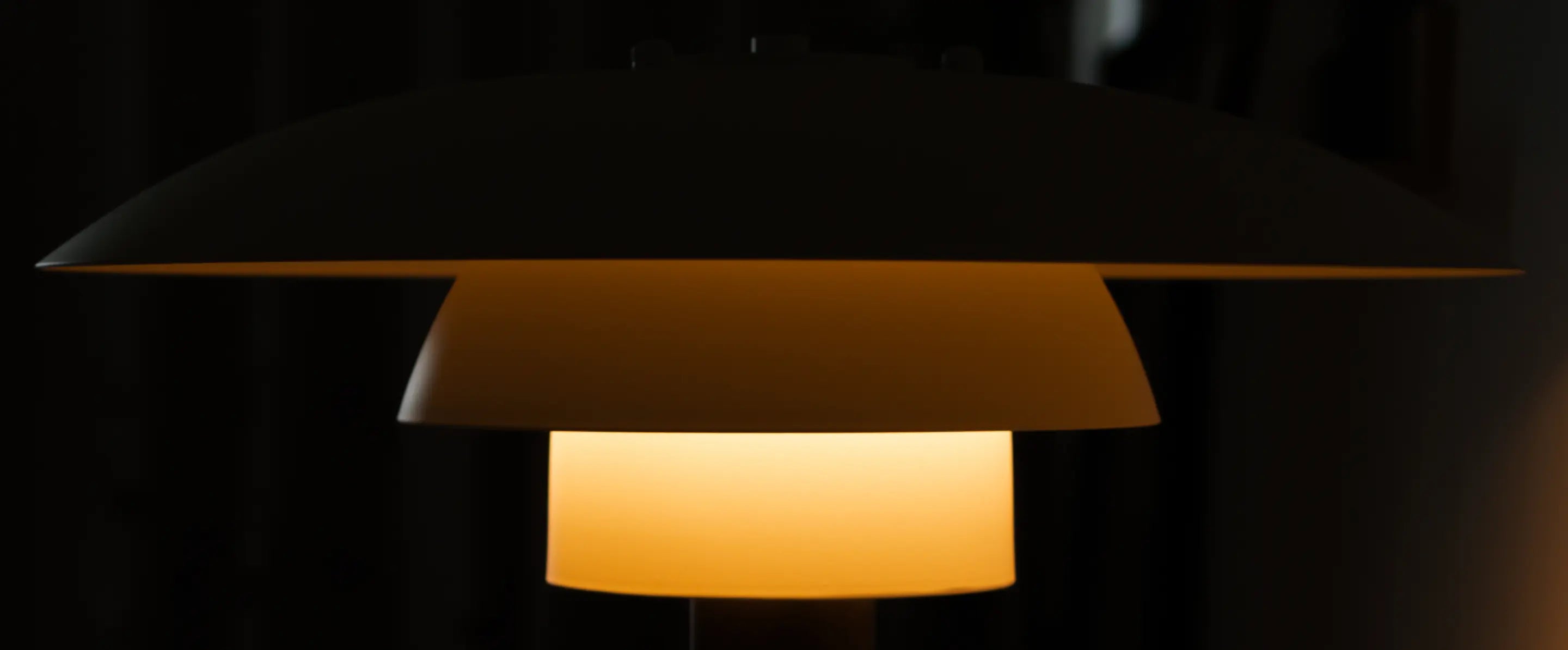 Close-up of Echo Lamp’s sculptural triple-layer shade glowing against a dark background
