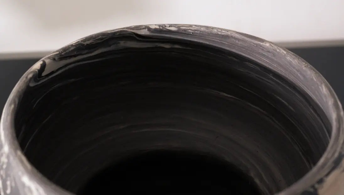 Close-up of a dark ceramic pot with a textured surface
