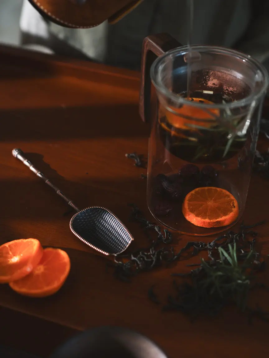 Vintage Spoon with a woven scoop and bamboo-inspired handle, placed beside a glass of brewed tea.