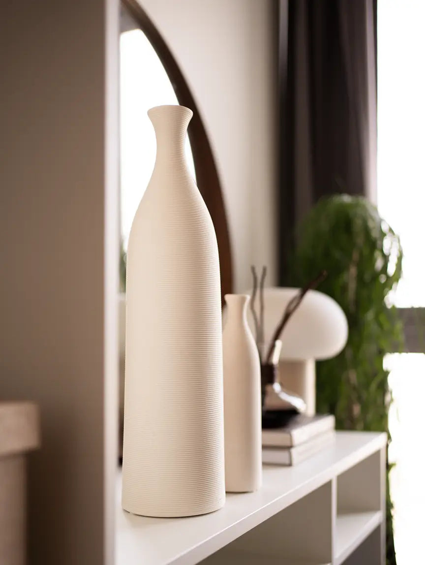 Tall Contour Ceramic Vase – White, displayed on a white shelf near a round mirror, styled with modern decor.