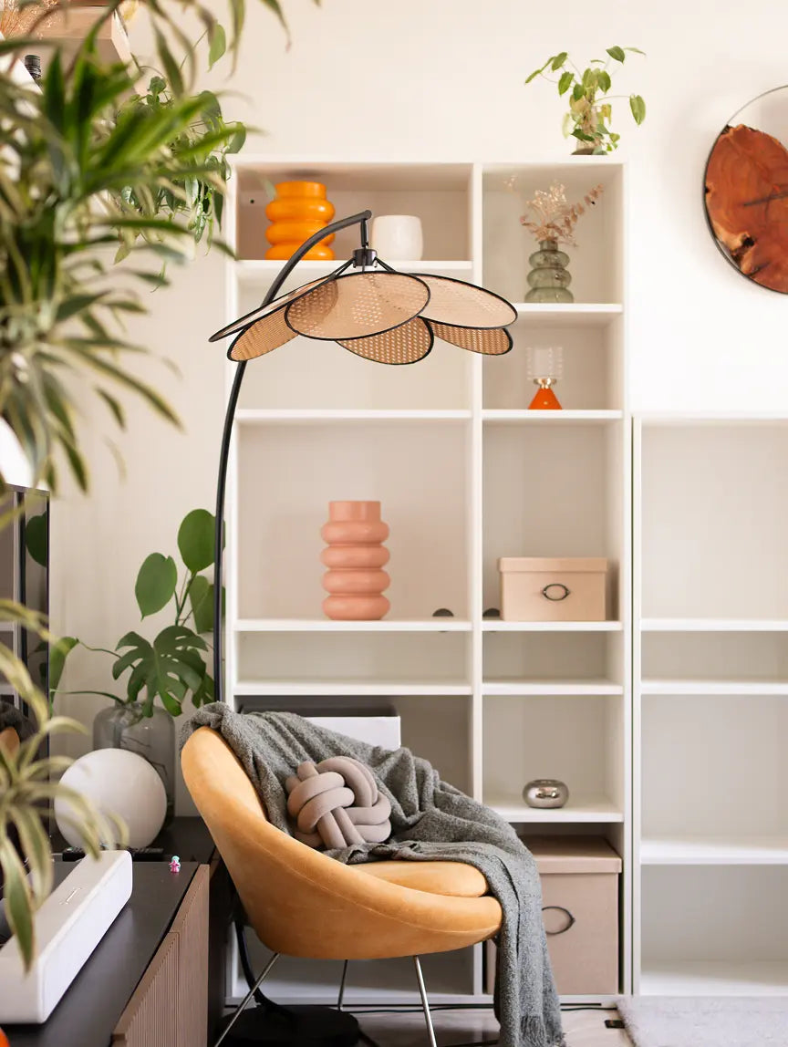 Hanai Floor Lamp with rattan shade and black arc frame, styled in a modern reading nook.