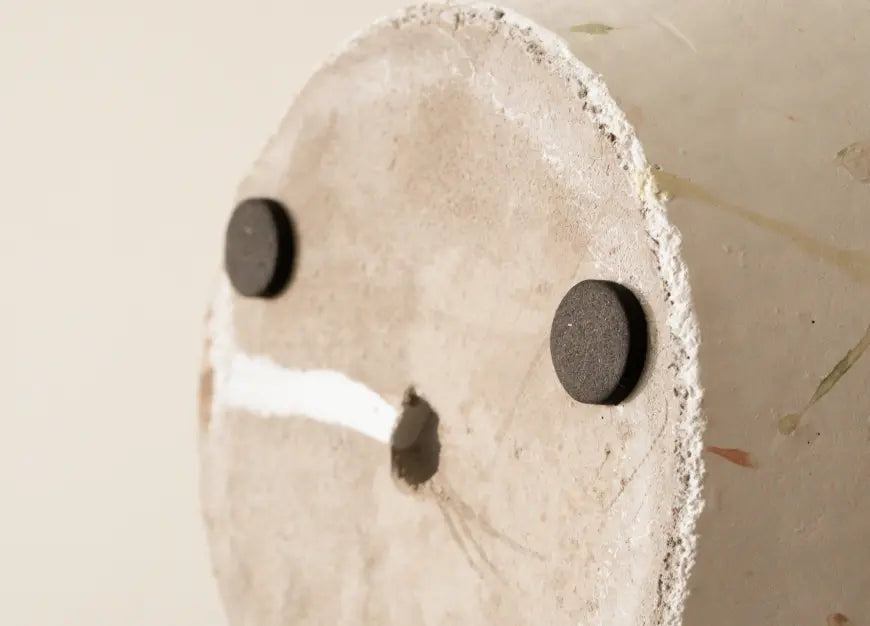 Close-up of the bottom of the Marvellous Concrete Planter - White, showing drainage hole and protective rubber pads.