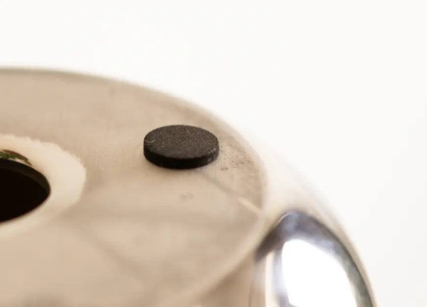 Close-up of the bottom of the Donut Chrome Candle Holder, featuring a protective anti-slip pad.
