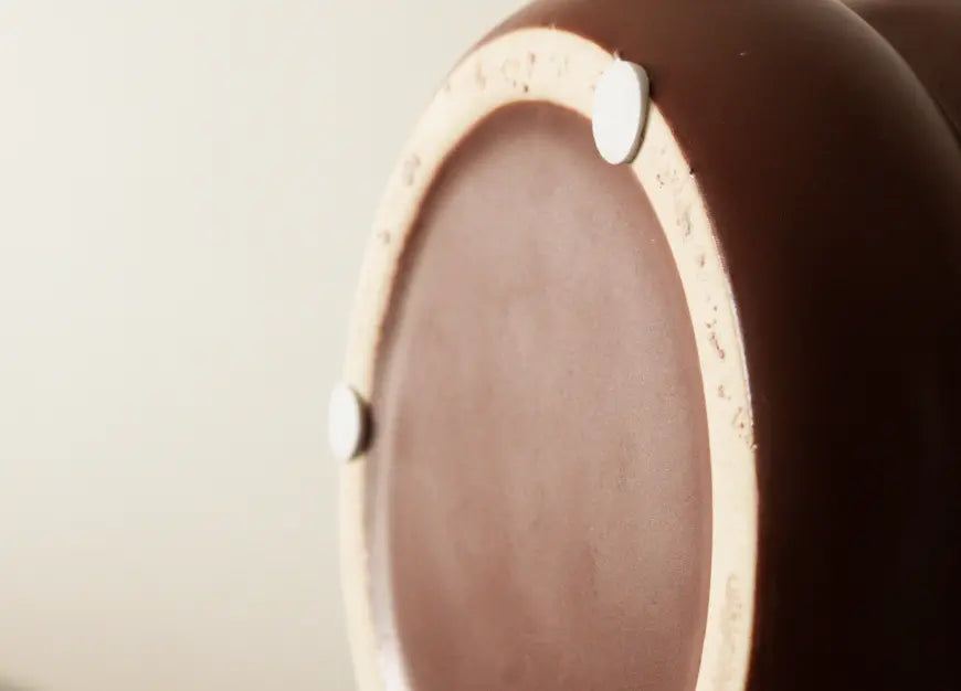 Bottom view of the Orbit Ceramic Planter - Maroon, showing protective pads for stability.