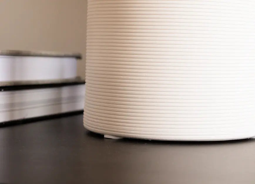 Base of the Contour Ceramic Vase showcasing its fine ribbed details and stable structure on a black surface.