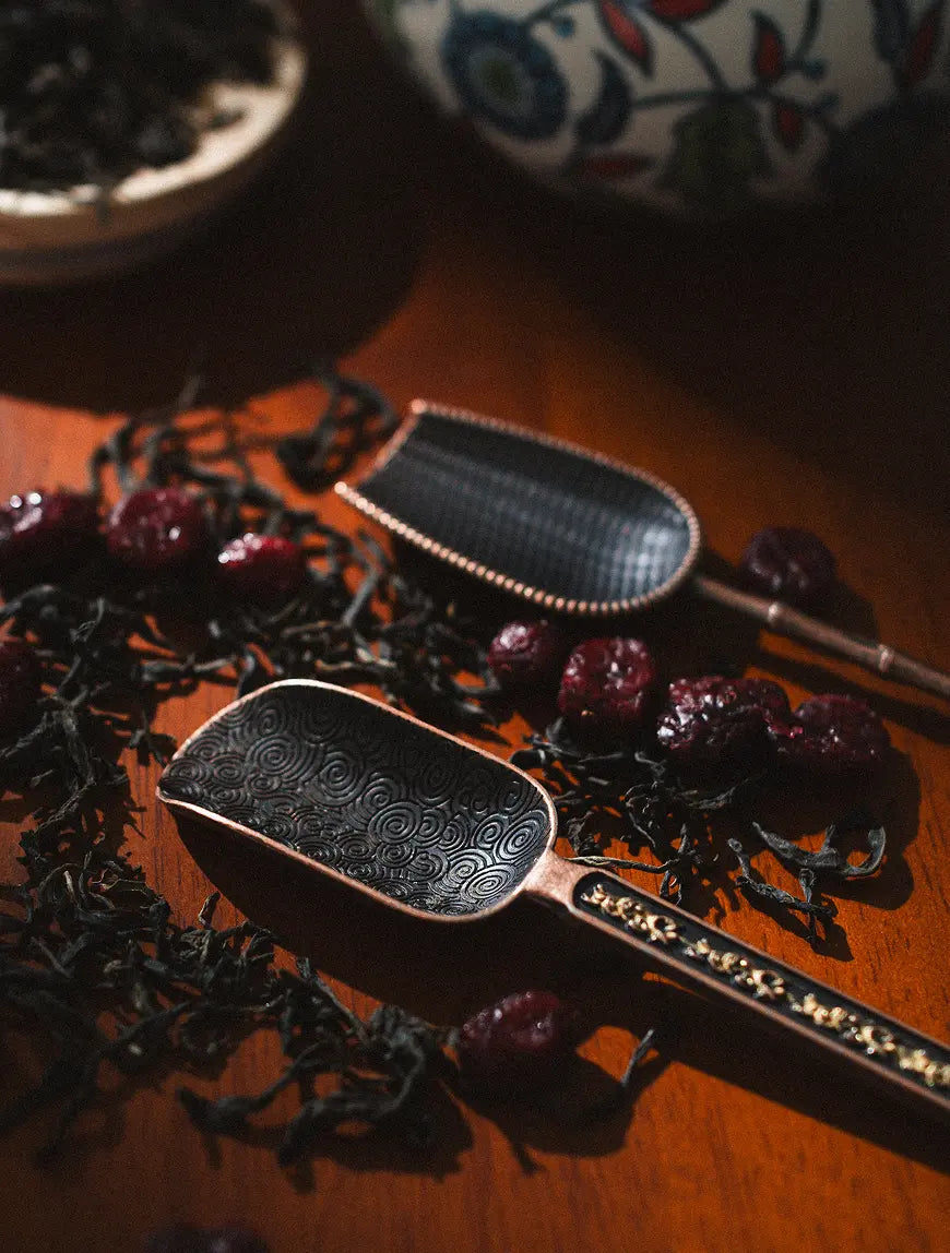 Pair of Vintage Spoons with ornate detailing, laid on a wooden surface.