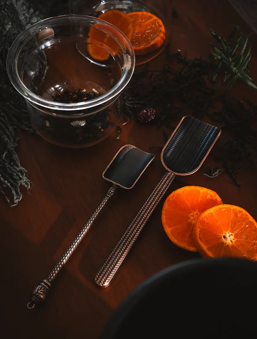 A set of Vintage Spoons displayed on a wooden surface with dried citrus and herbs.