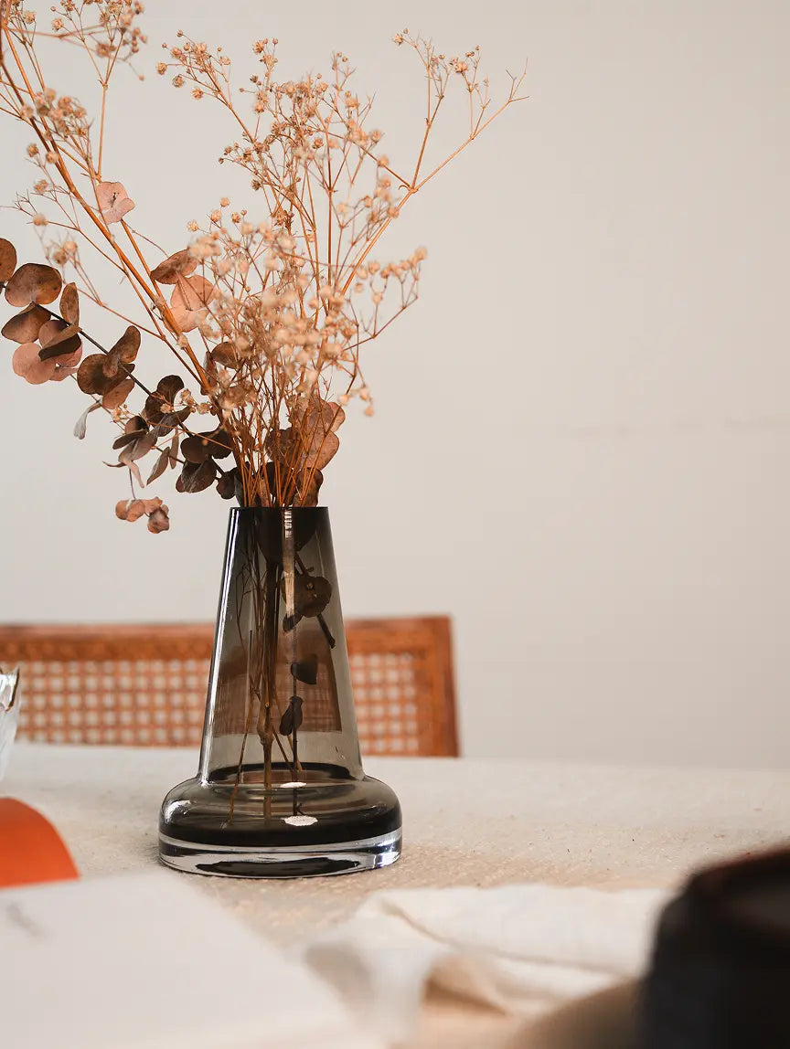 Pitcher Glass Vase - Long Neck with a smoky tint, holding dried florals on a neutral-toned table.