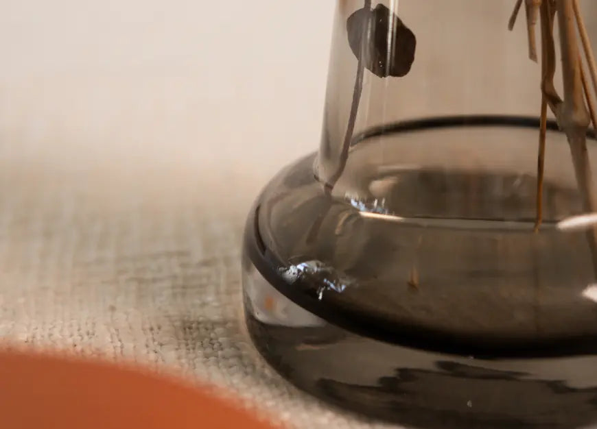 Close-up of the Pitcher Glass Vase - Long Neck’s thick base, showcasing its sturdy design and smooth transparency.