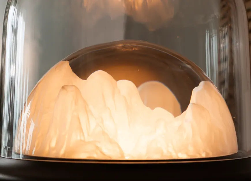Decorative lamp with mountain design inside a glass dome