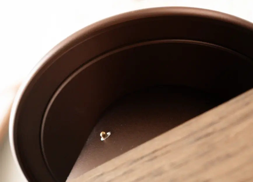 Close-up of a base of a cordless table lamp with a touch sensor on a wooden surface.