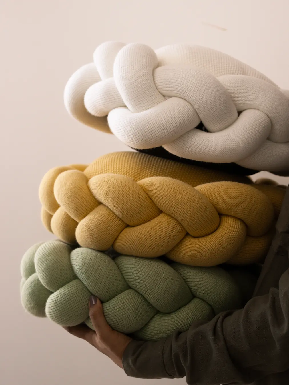 Stack of Halo Nest Cushions in light green, yellow, and white, showcasing color options.