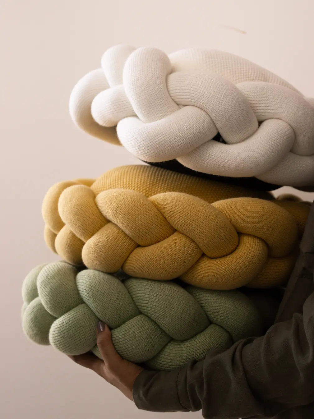 Stack of Gharko Halo Nest Cushions in white, yellow, and green colors