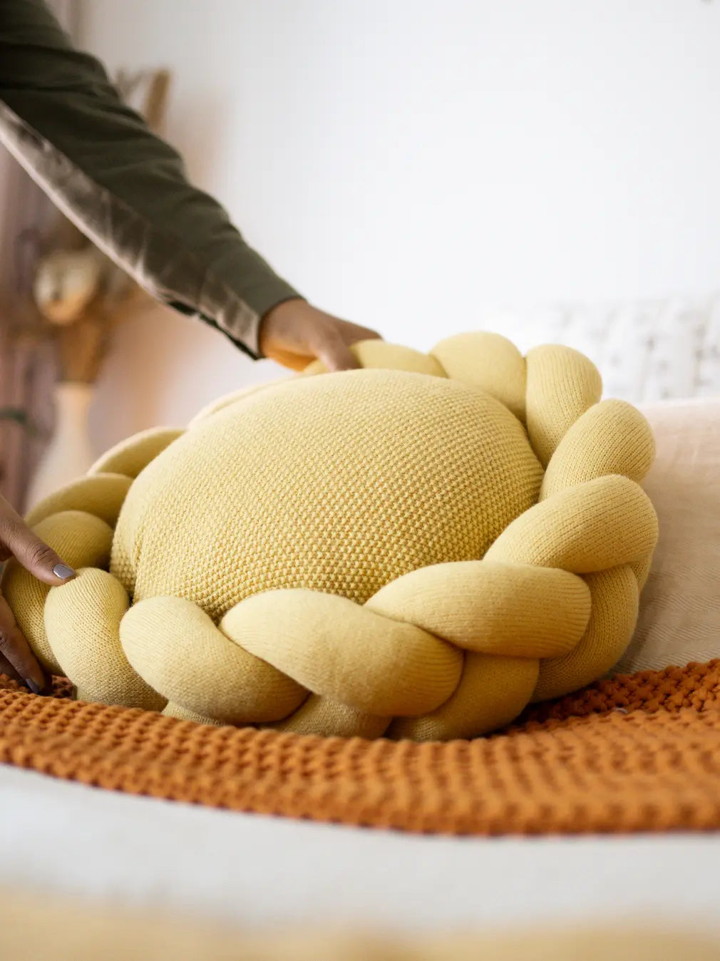 Person placing yellow Halo Nest Cushion on bed