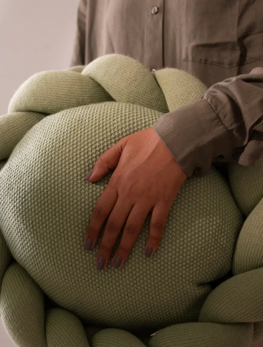 Person holding Halo Nest Cushion Green showcasing texture