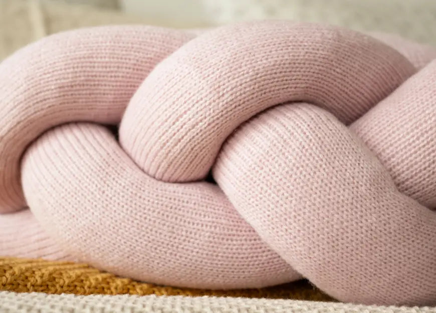 Close-up of pink knot detailing on Gharko knitted Halo Nest Cushion