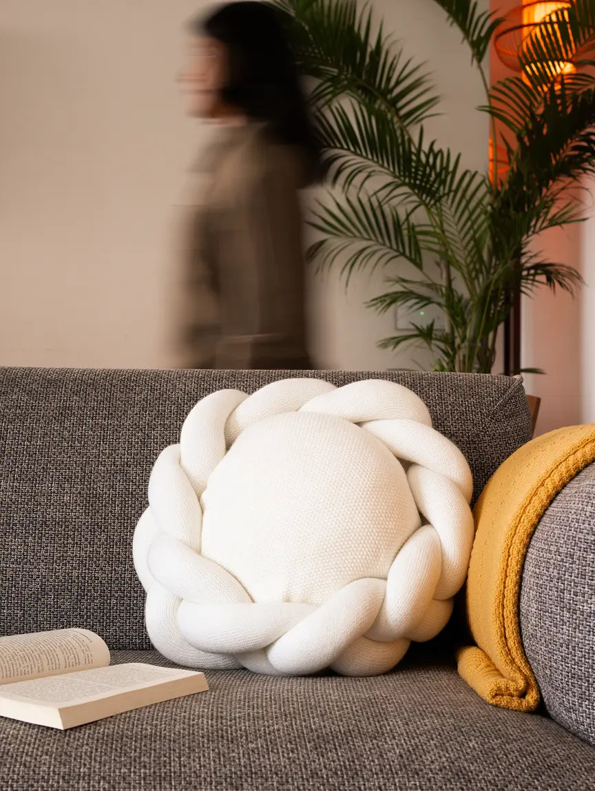White Halo Nest Cushion on grey sofa with yellow throw