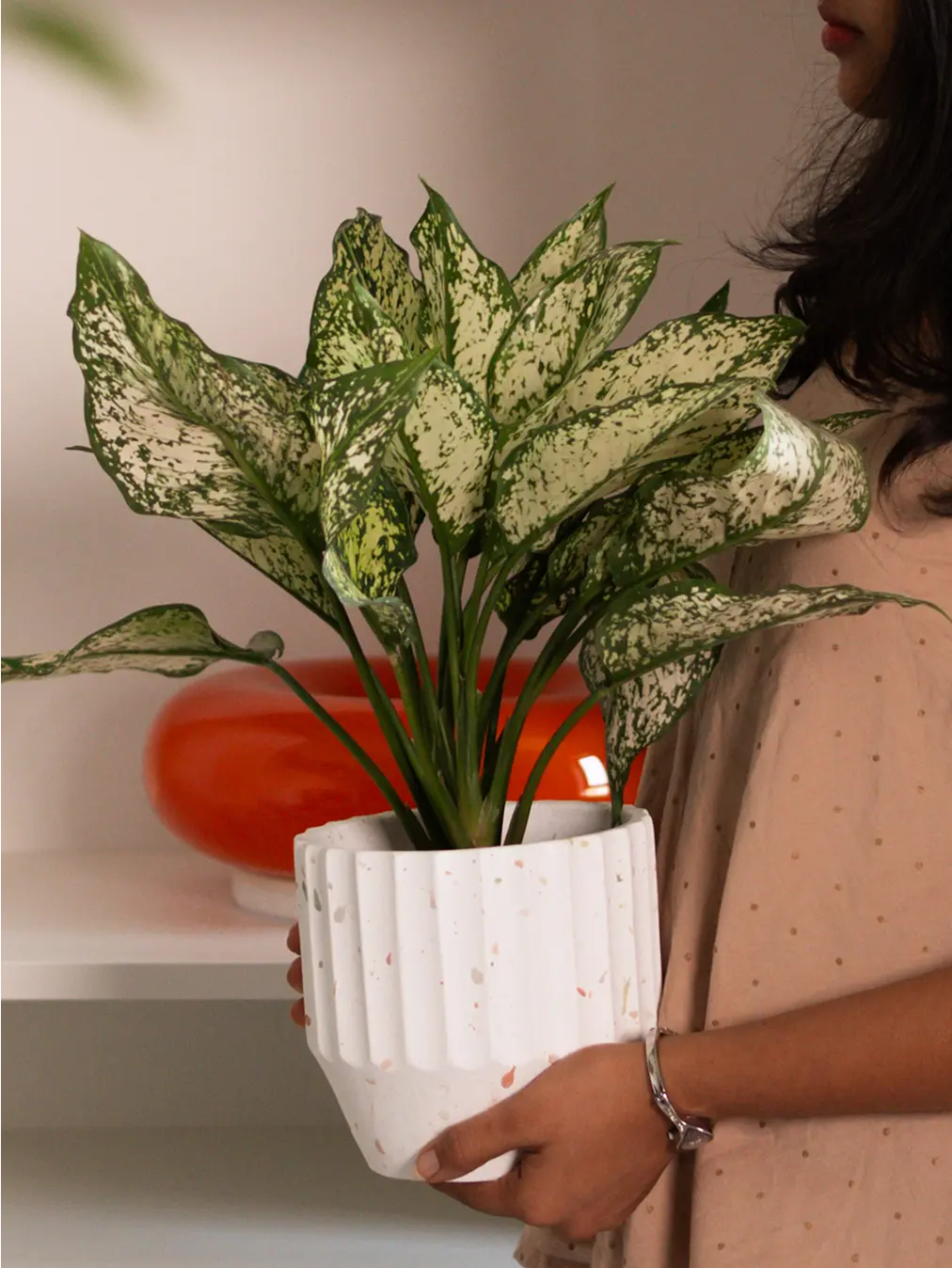 Person holding the Marvellous Concrete Planter - White, showcasing its terrazzo pattern and sculptural form.
