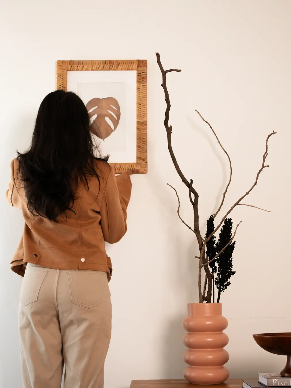 Orbit ceramic vase - peach with a layered silhouette, styled with black dried flowers on a wooden surface.