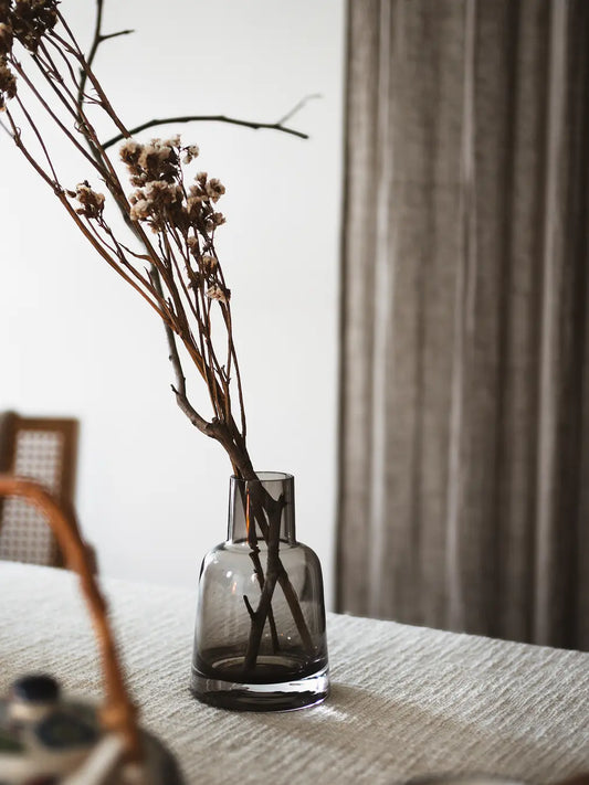 Pitcher Glass Vase - Small Neck with dried branches on a dining table, creating a rustic charm.