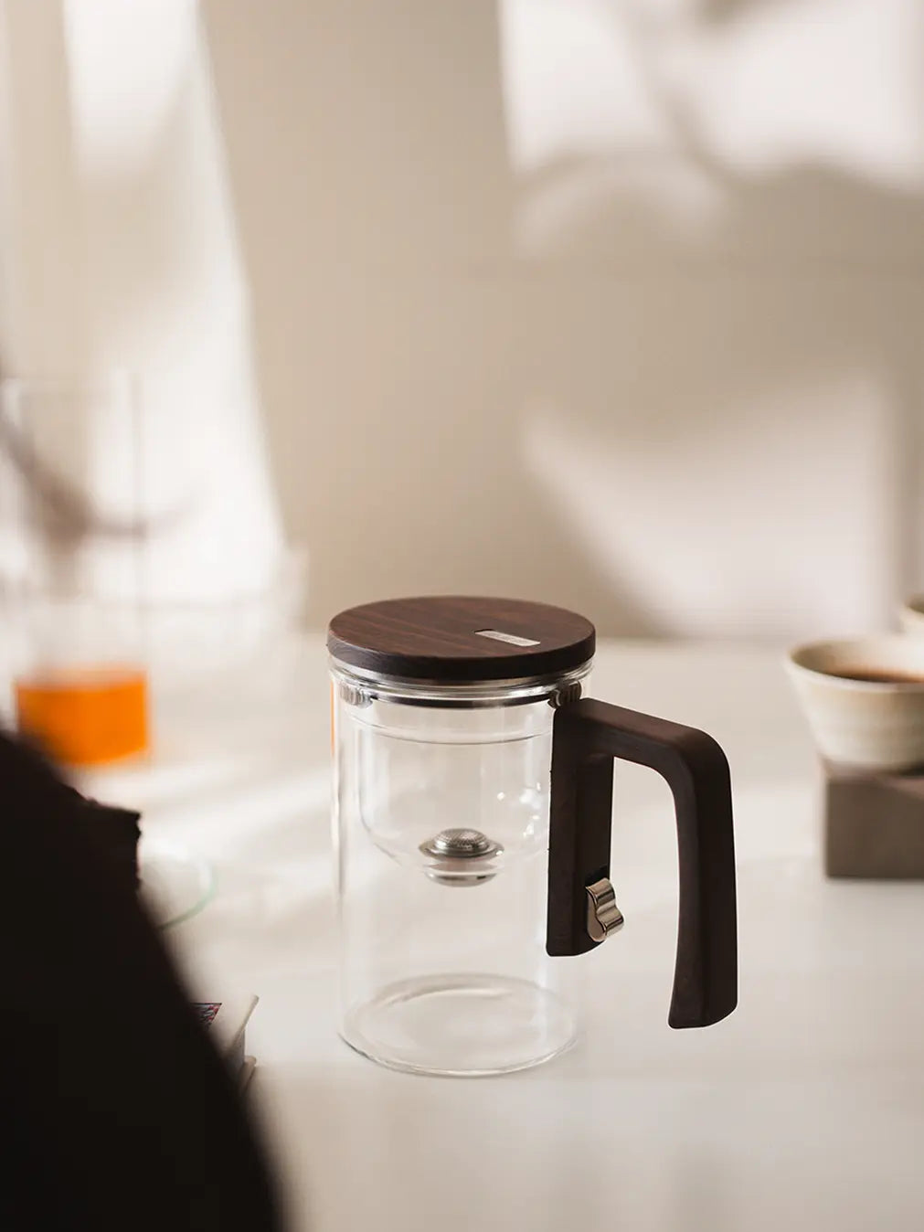 Pourfect Tea Infuser with a sleek glass design, wooden lid, and ergonomic handle.