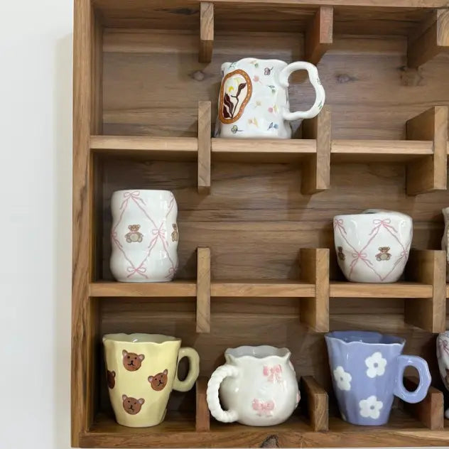 Collection of ceramic mugs on a wooden Cup shelf