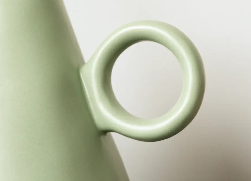 Minimal circular handle detail of modern ceramic flower vase design.