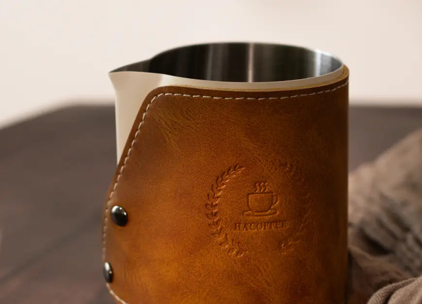 Close-up of Brista Milk Pitcher’s brown leather sleeve, showcasing embossed detailing and stitched edges for a premium touch.