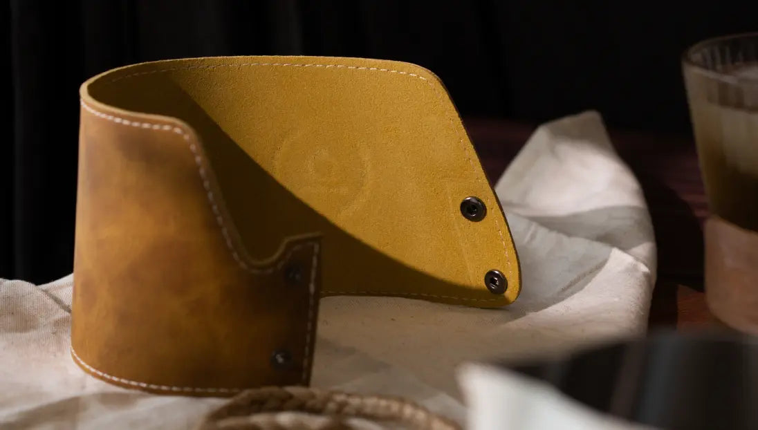 Brista Milk Pitcher with a detachable leather sleeve, highlighting its easy-to-remove snap-button design for convenience