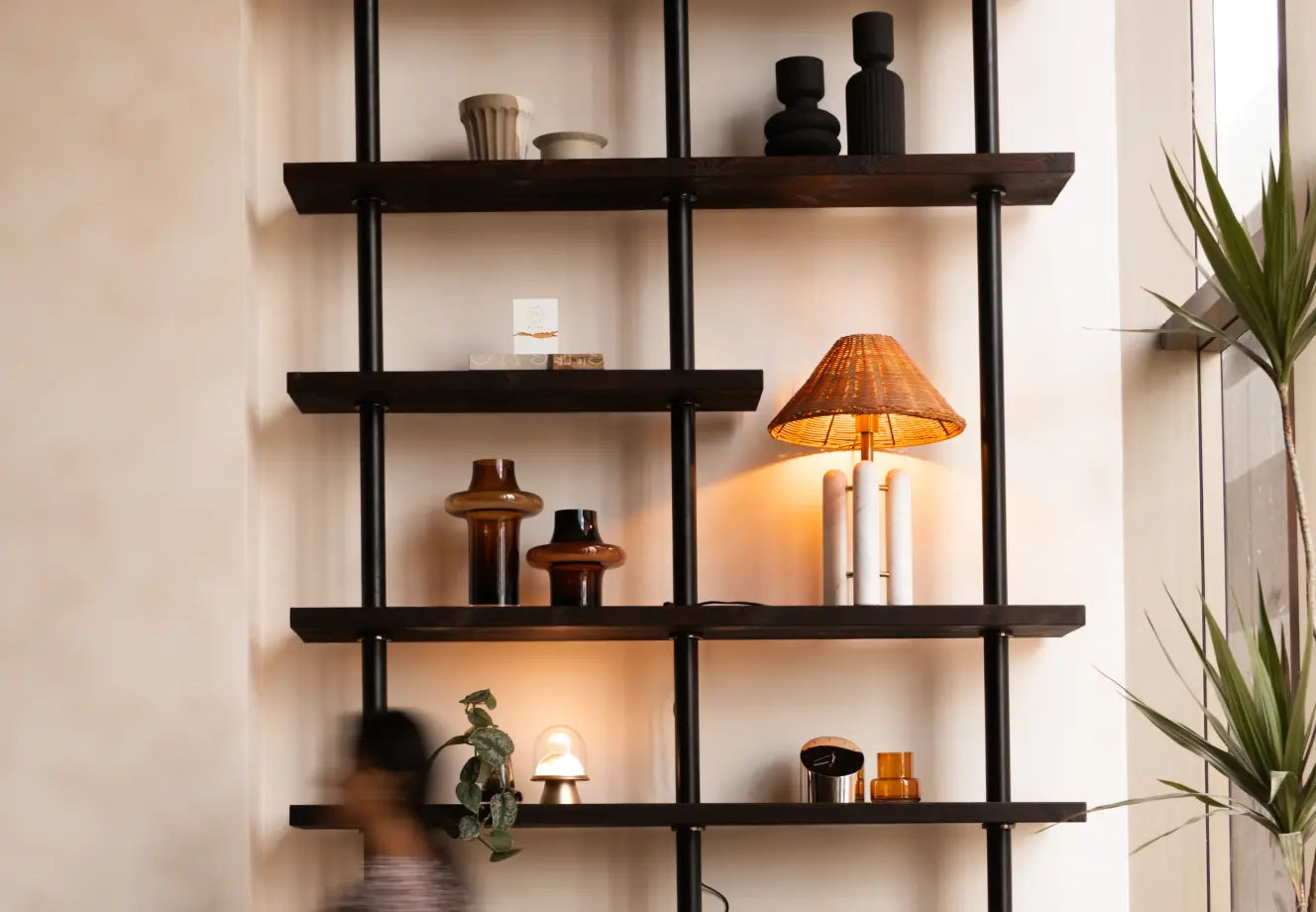 Decorative shelving with vases, table lamp and plants styled in thoughtful accent groupings