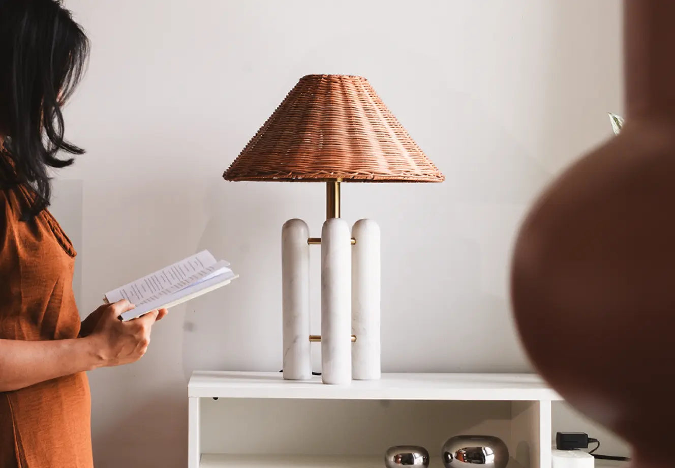 Modern marble table lamp with rattan shade styled in a cosy reading corner
