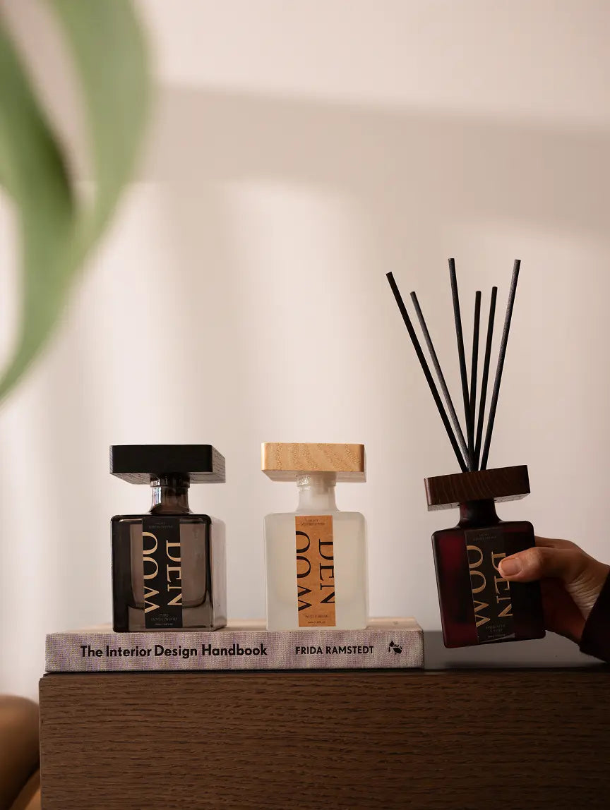 Premium reed diffusers with wooden caps in modern glass bottles for home fragrance.