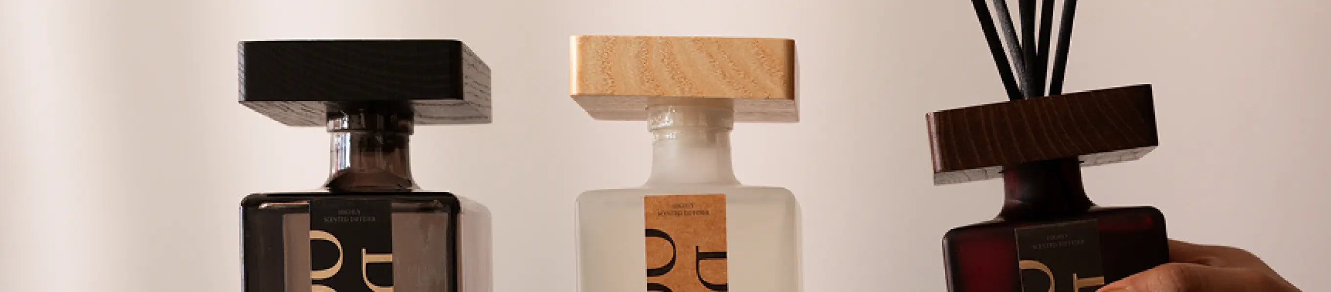 Premium reed diffusers with wooden caps in modern glass bottles for home fragrance.